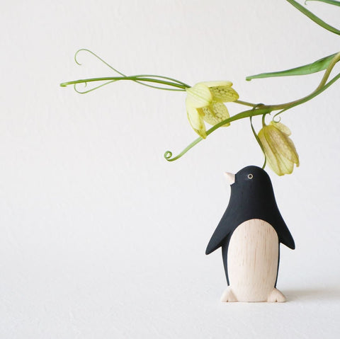 Animal en bois penguin sous une fleur 